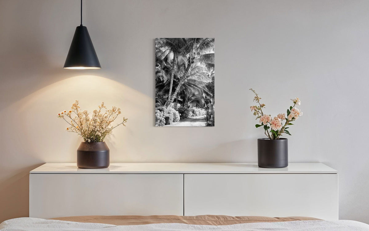 A piece of black and white Kauai art showing Anini Road hangs in a dining room.