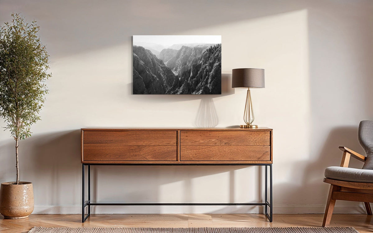 A piece of Colorado art showing a photo of the Black Canyon National Park in Gunnison hangs over a console.