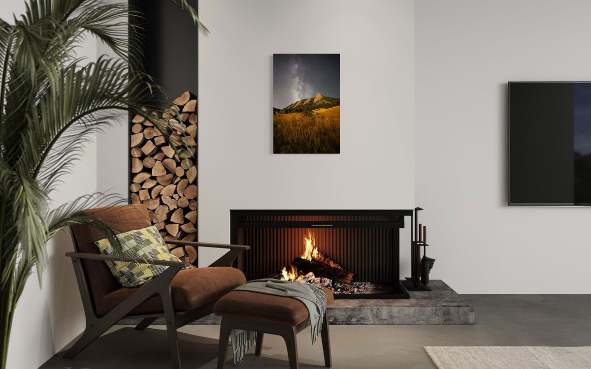 A piece of Boulder art showing the Flatirons with the Milky Way above hangs over a fireplace.