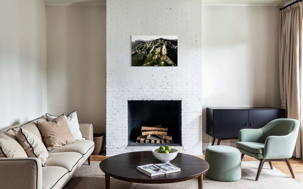 A piece of Boulder art showing an areal photo of the Flatirons along Colorado's Front Range hangs over a fireplace.