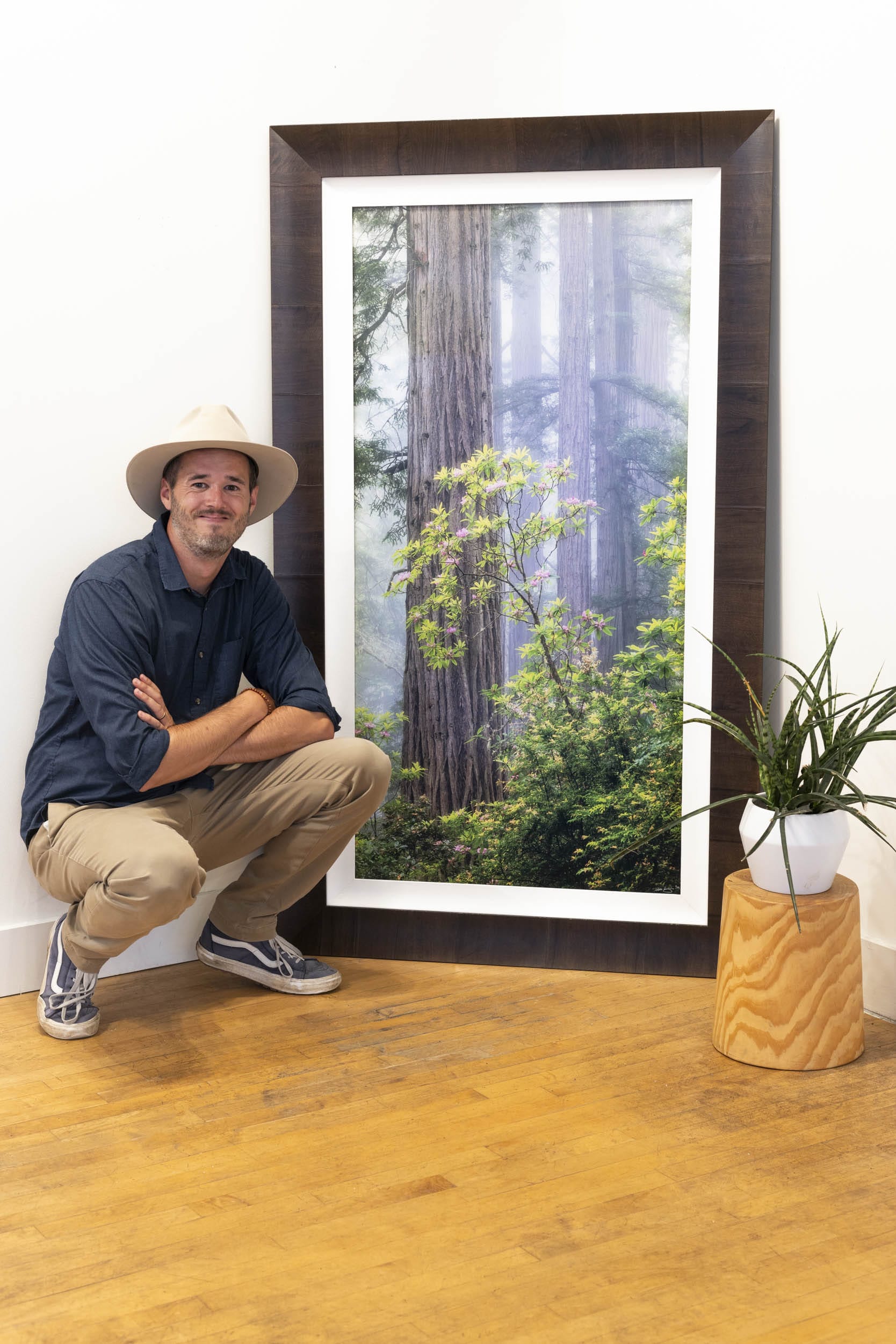 Lars Gesing with a framed fine art photograph from the California redwoods.