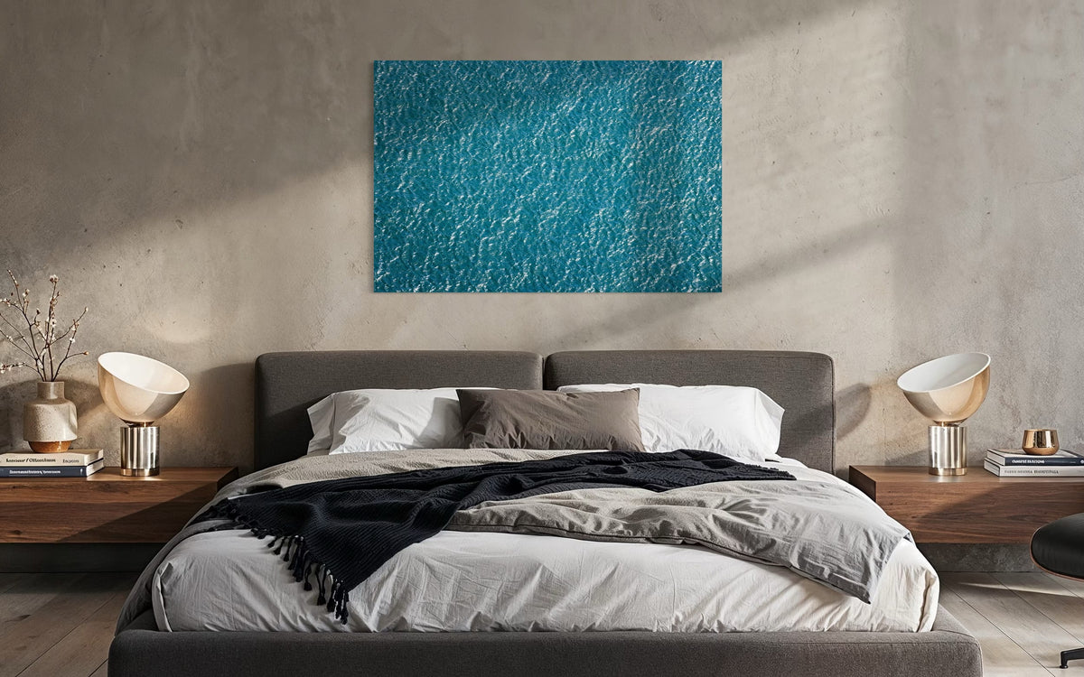An abstract ocean photo hangs above a bed. | Lars Gesing Fine Art | Coastal Wall Art
