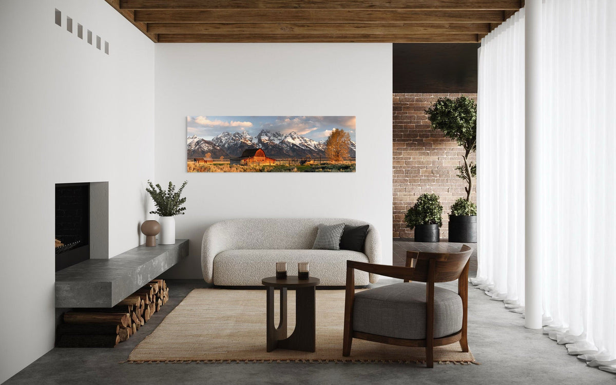 A piece of Jackson Hole art showing a photo of Mormon Row at the foot of the Grand Tetons hangs in a modern rustic living room space.