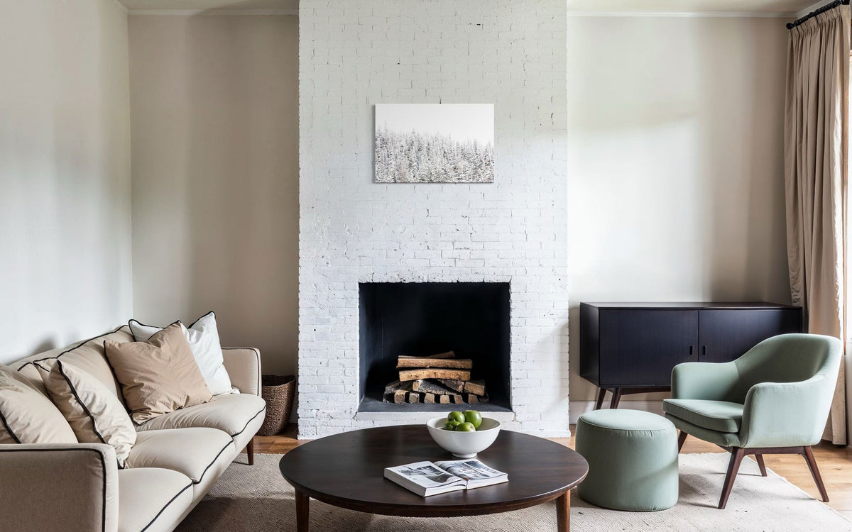 A piece of Steamboat Springs art showing snowy trees outside the Colorado ski resort hangs above a stone fireplace.
