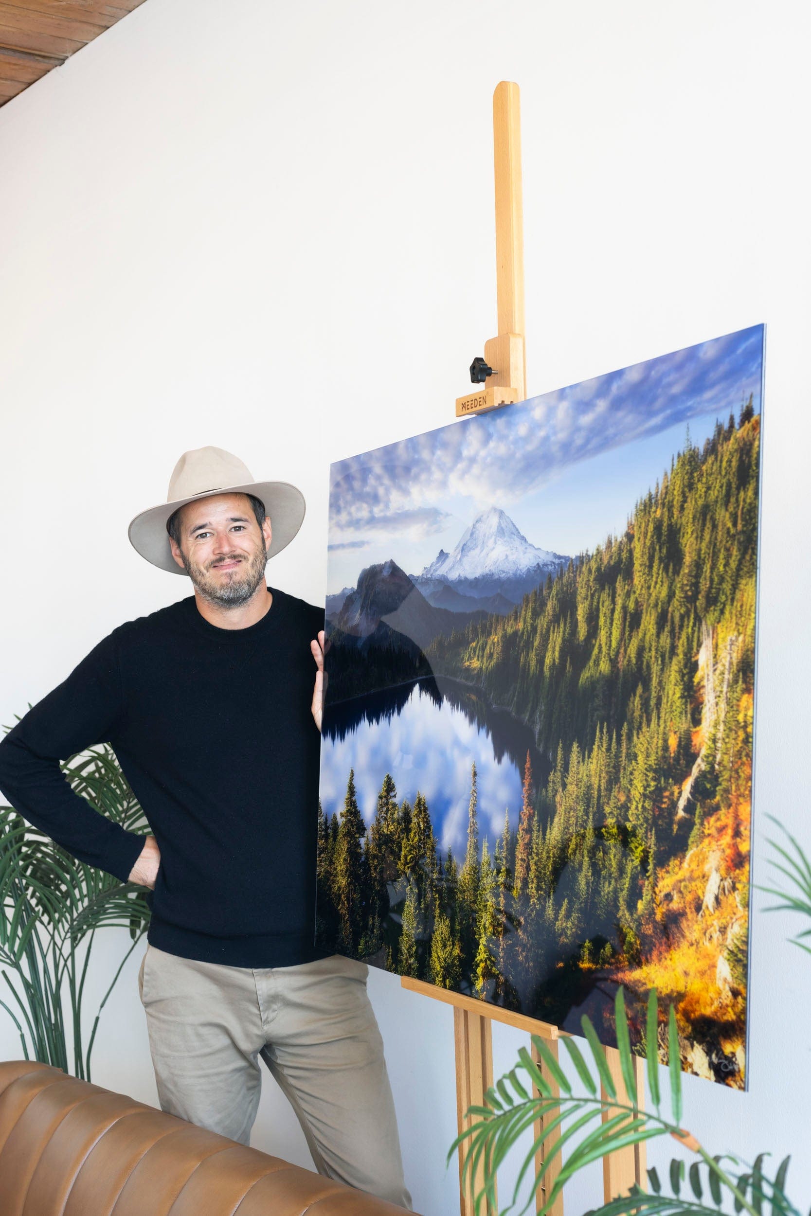 West Seattle artist Lars Gesing next to his Mount Rainier artwork showing a photo of Summit Lake.