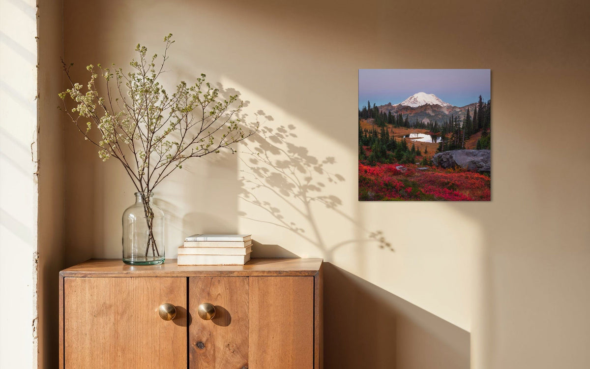 A piece of Mount Rainier art showing a Tipsoo Lake photo hangs next to a window.