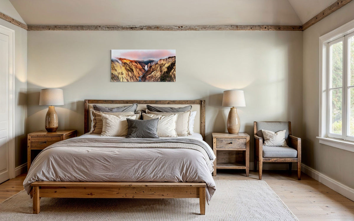 A piece of Yellowstone art showing a canyon photo from Artist Point hangs above a bed.