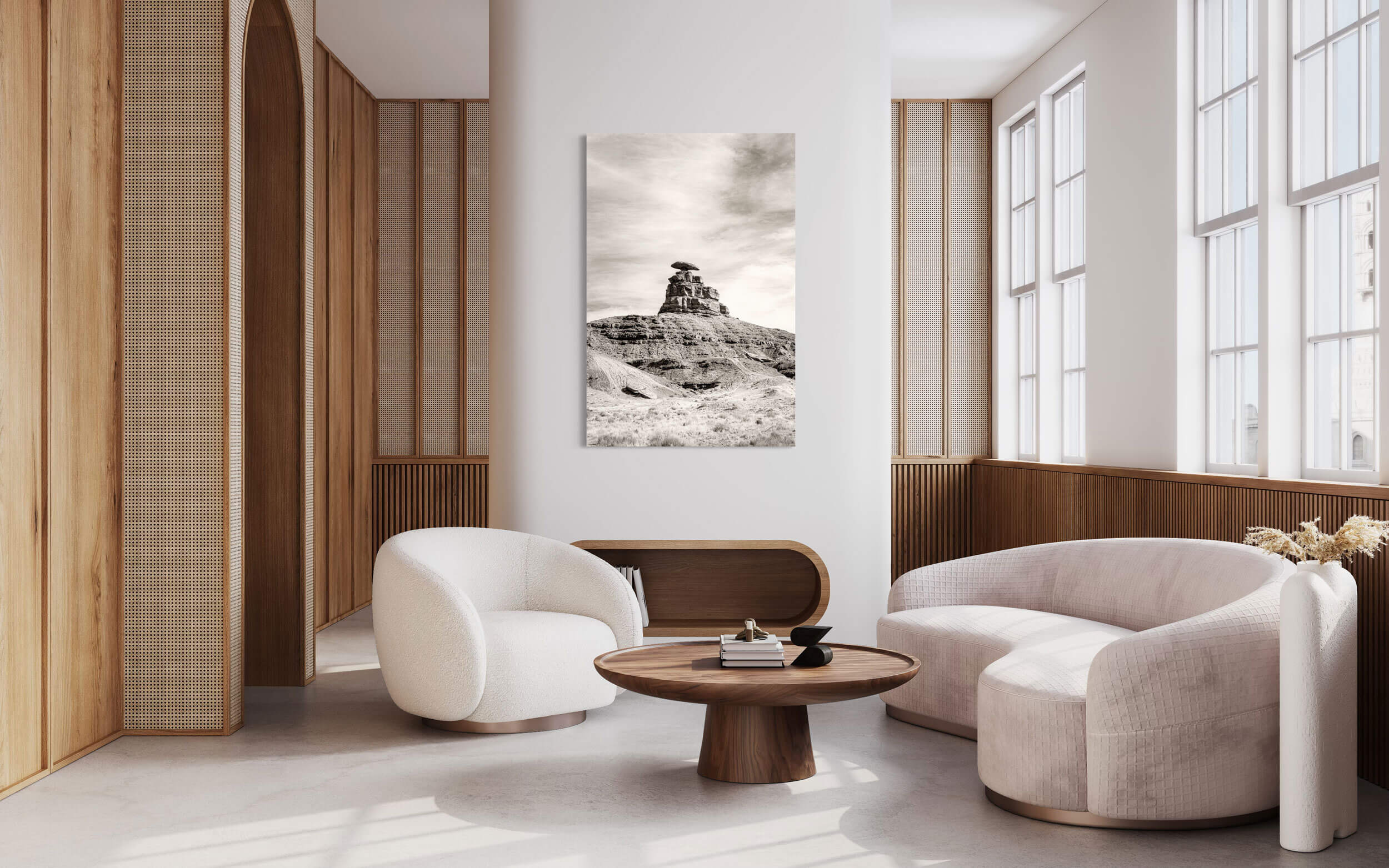 A piece of Utah art showing a black and white photo of Mexican Hat hangs in a living room.