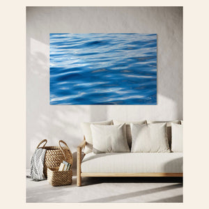 A piece of Anacortes art showing a photo of the water, as seen from aboard a whale watching boat tour, hangs in a living room.