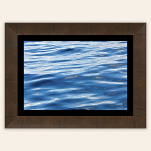 A piece of framed Anacortes art shows a photo of the water, as seen from aboard a whale watching boat tour.