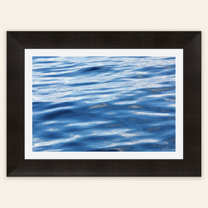 A piece of framed Anacortes art shows a photo of the water, as seen from aboard a whale watching boat tour.