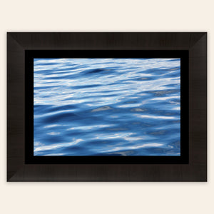 A piece of framed Anacortes art shows a photo of the water, as seen from aboard a whale watching boat tour.