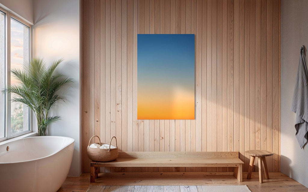 A piece of Big Sur Wall Art showing a sunset photo hangs in a bathroom.