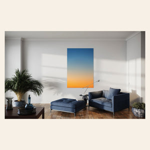 This piece of Big Sur Wall Art showcases a sunset photo hangs in a living room.