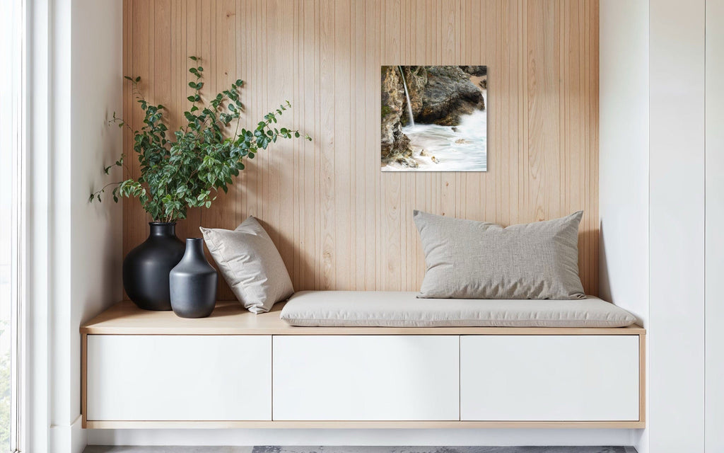 A piece of Big Sur art showing a waterfall photo hangs in a sitting area.