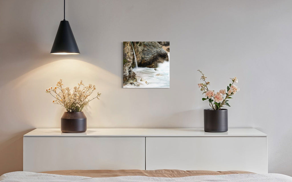 A piece of Big Sur art showing a waterfall photo hangs in a dining room.