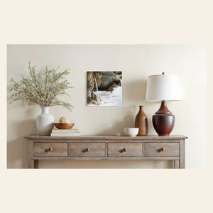 A piece of Big Sur art showing a waterfall photo hangs in a beautiful home.