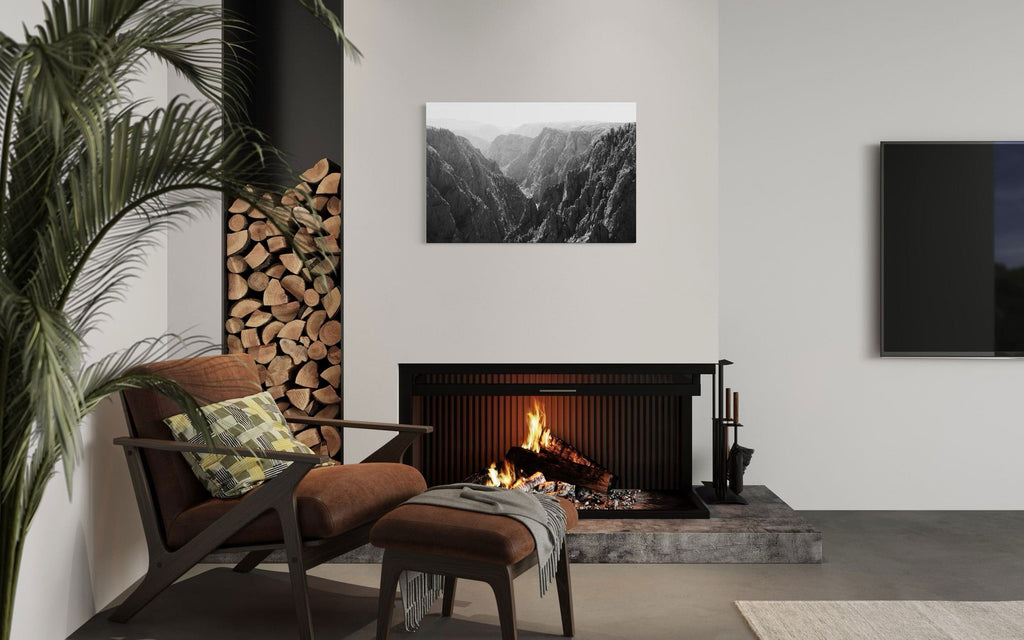 A piece of Colorado art showing a photo of the Black Canyon National Park in Gunnison hangs over a fireplace.