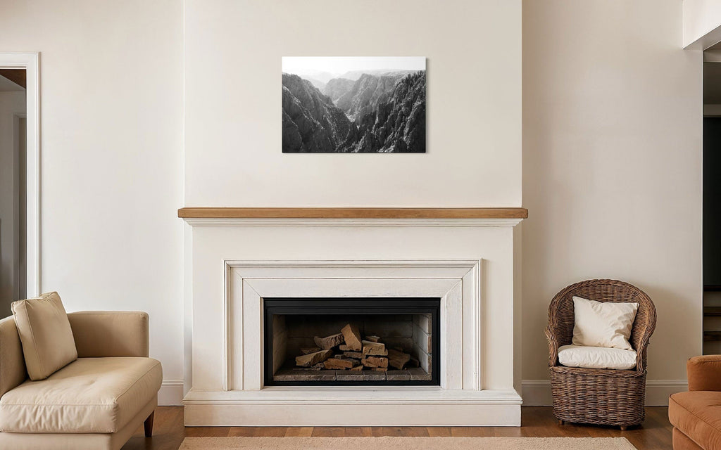 A piece of Colorado art showing a photo of the Black Canyon National Park in Gunnison hangs above a fireplace mantel.