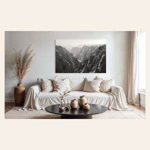 A piece of Colorado art showing a photo of the Black Canyon National Park in Gunnison hangs above a couch.