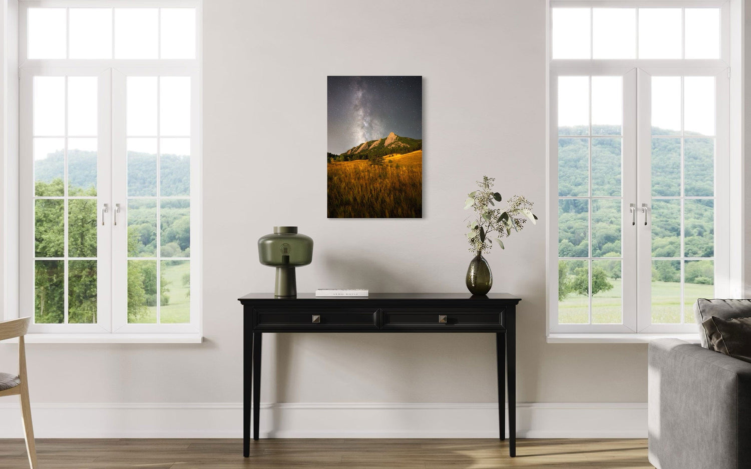 A piece of Boulder art showing the Flatirons with the Milky Way above hangs over a side table.