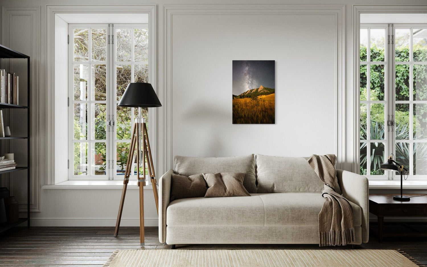A piece of Boulder art showing the Flatirons with the Milky Way above hangs above a couch.