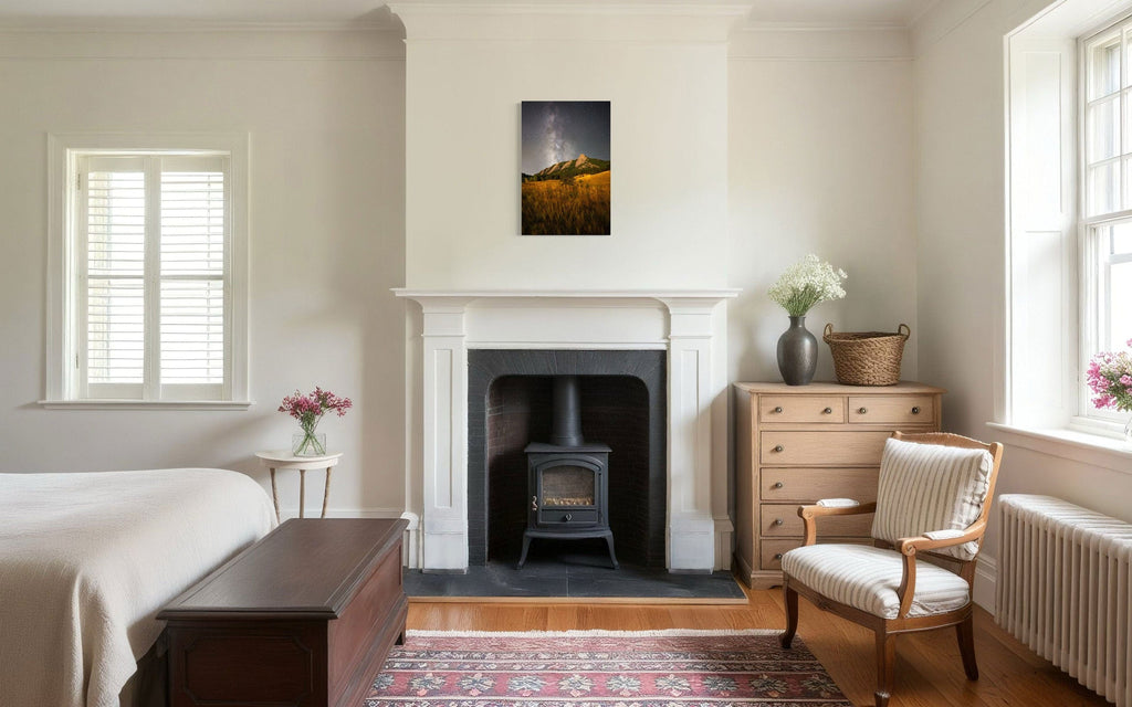 A piece of Boulder art showing the Flatirons with the Milky Way above hangs above a bedroom fireplace.