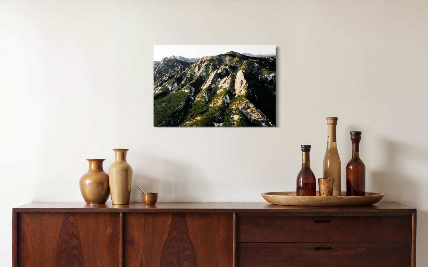 A piece of Boulder art showing an areal photo of the Flatirons along Colorado's Front Range hangs above a console.
