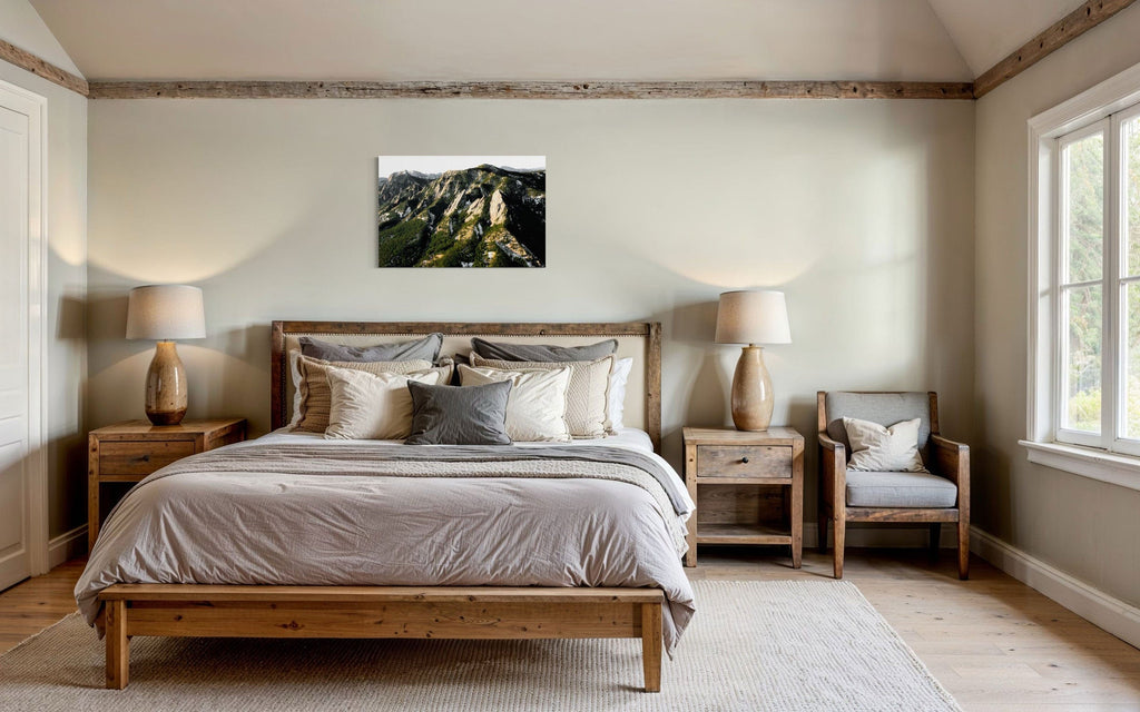 A piece of Boulder art showing an areal photo of the Flatirons along Colorado's Front Range hangs above a bed.