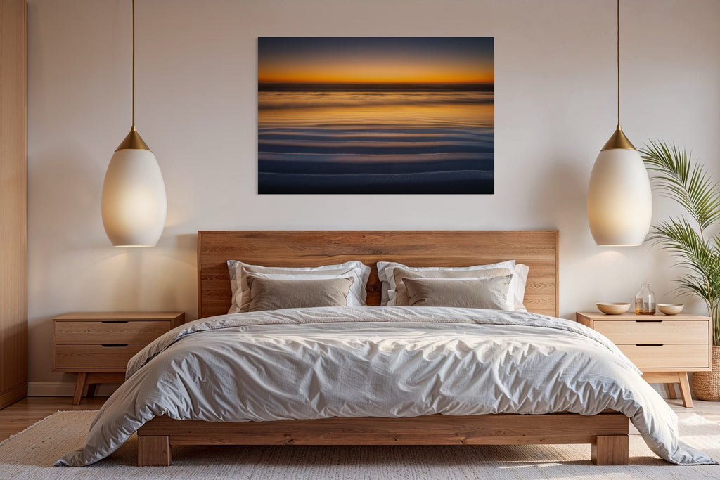 A Lars Gesing Fine Art coastal photograph of the sunset colors in Cannon Beach hangs in a bedroom.