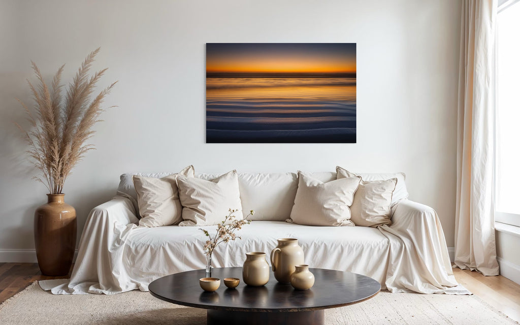 A Cannon Beach sunset photo hangs above a couch. | Lars Gesing Fine Art | Coastal Wall Art