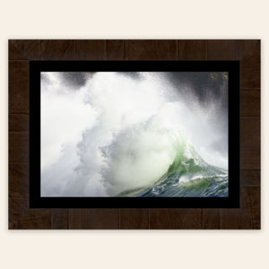 A piece of framed Washington wall art shows the waves at Cape Disappointment.