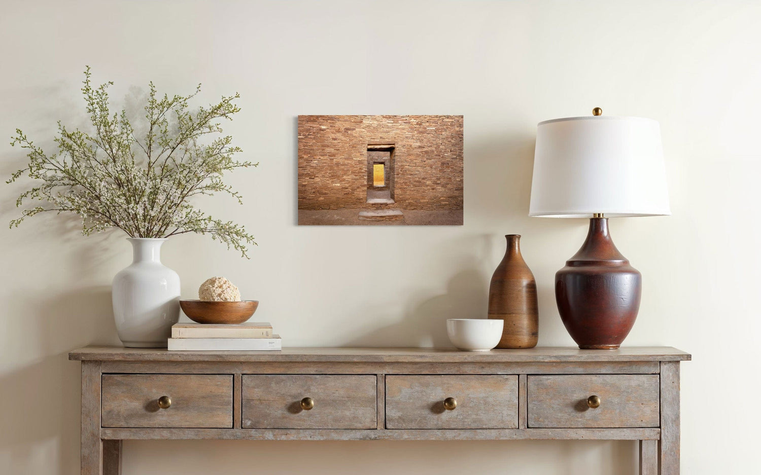 A piece of New Mexico art showing a Chaco Canyon photo hangs above a console.