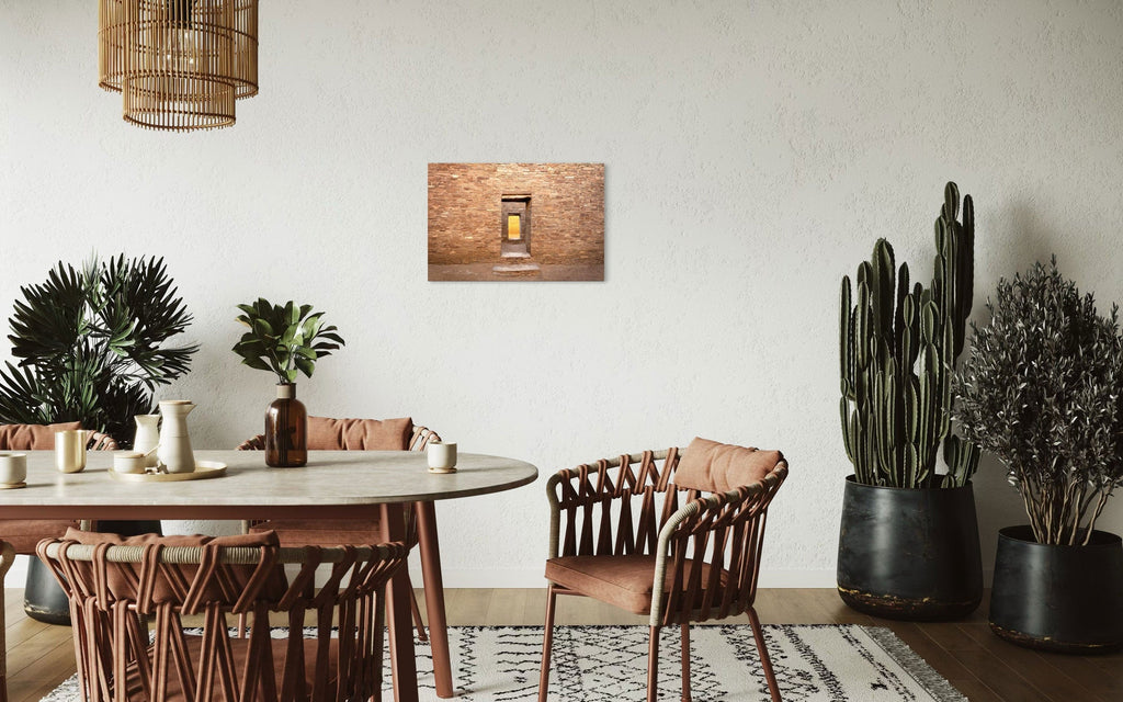 A piece of New Mexico art showing a Chaco Canyon photo hangs in a dining room.