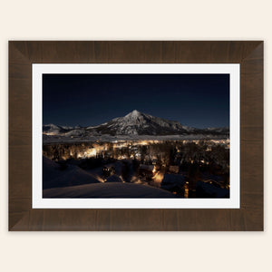 A framed piece of Crested Butte art showing the Colorado mountain town at night.