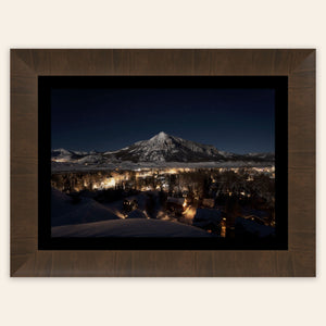 A framed piece of Crested Butte art showing the Colorado mountain town at night.