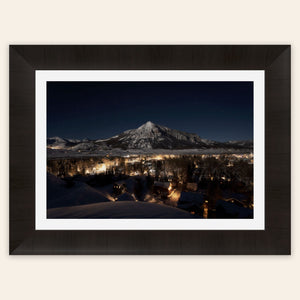 A framed piece of Crested Butte art showing the Colorado mountain town at night.