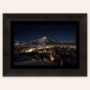 A framed piece of Crested Butte art showing the Colorado mountain town at night.