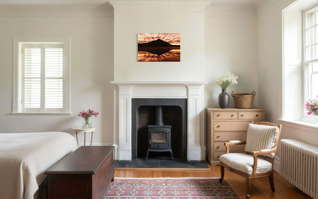 A piece of Crested Butte art showing a photo of the mountain at sunrise from Peanut Lake hangs above a bedroom fireplace.
