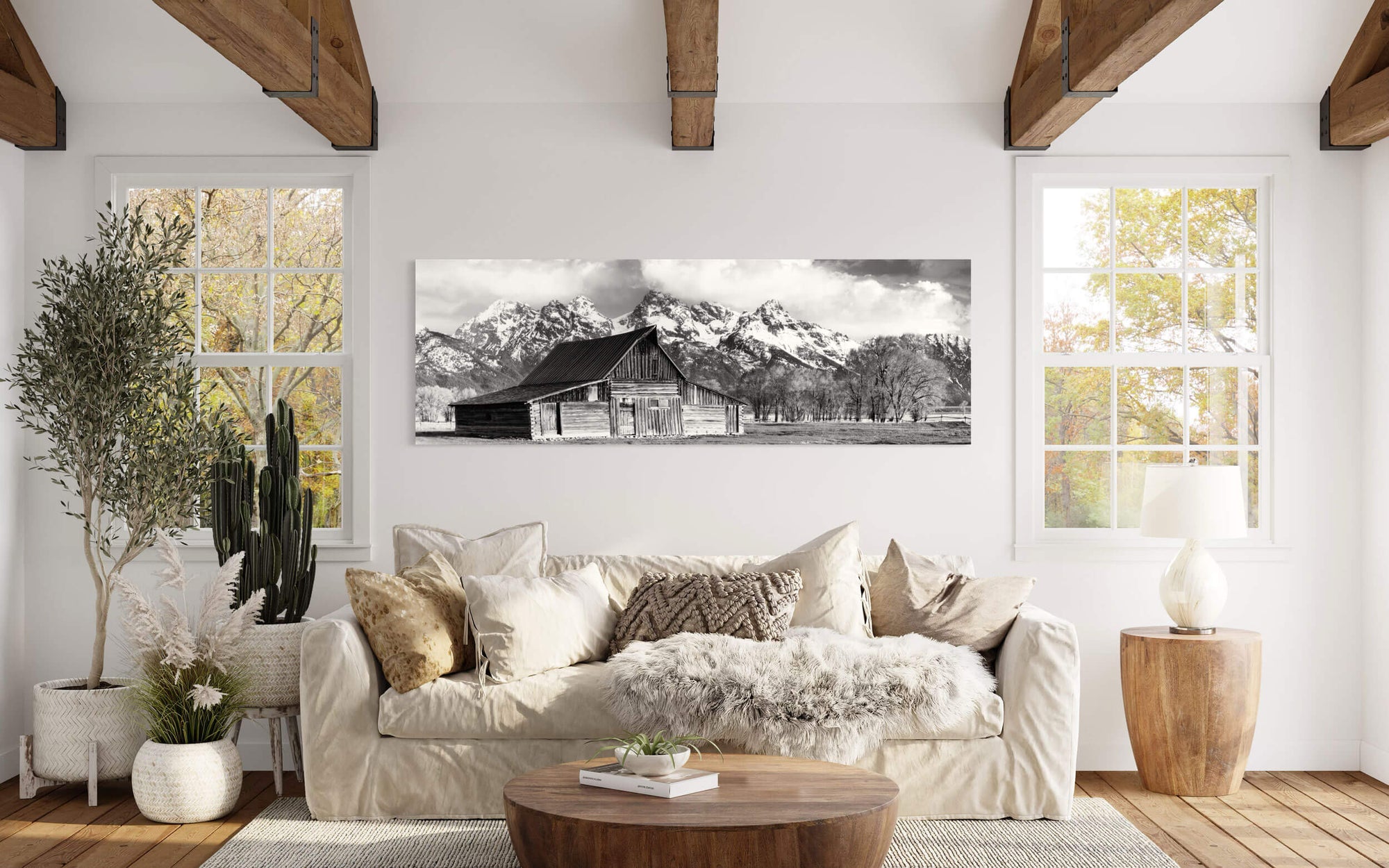 A black and white photograph of the barn in Grand Teton National Park hangs in a living room.