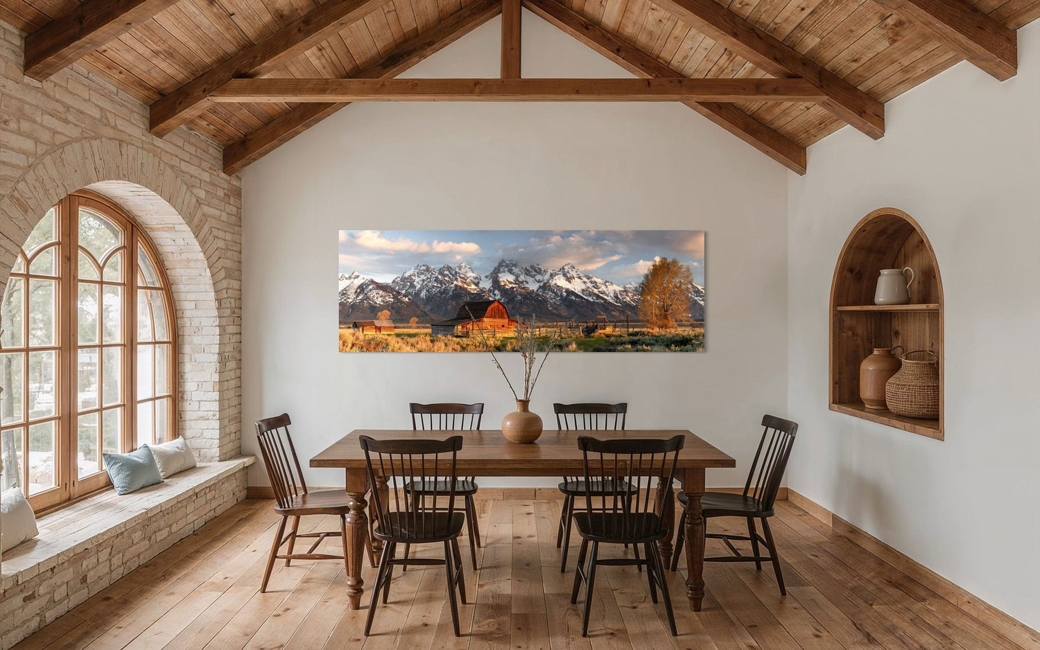 A piece of Jackson Hole art showing a photo of Mormon Row at the foot of the Grand Tetons hangs in a large dining room.