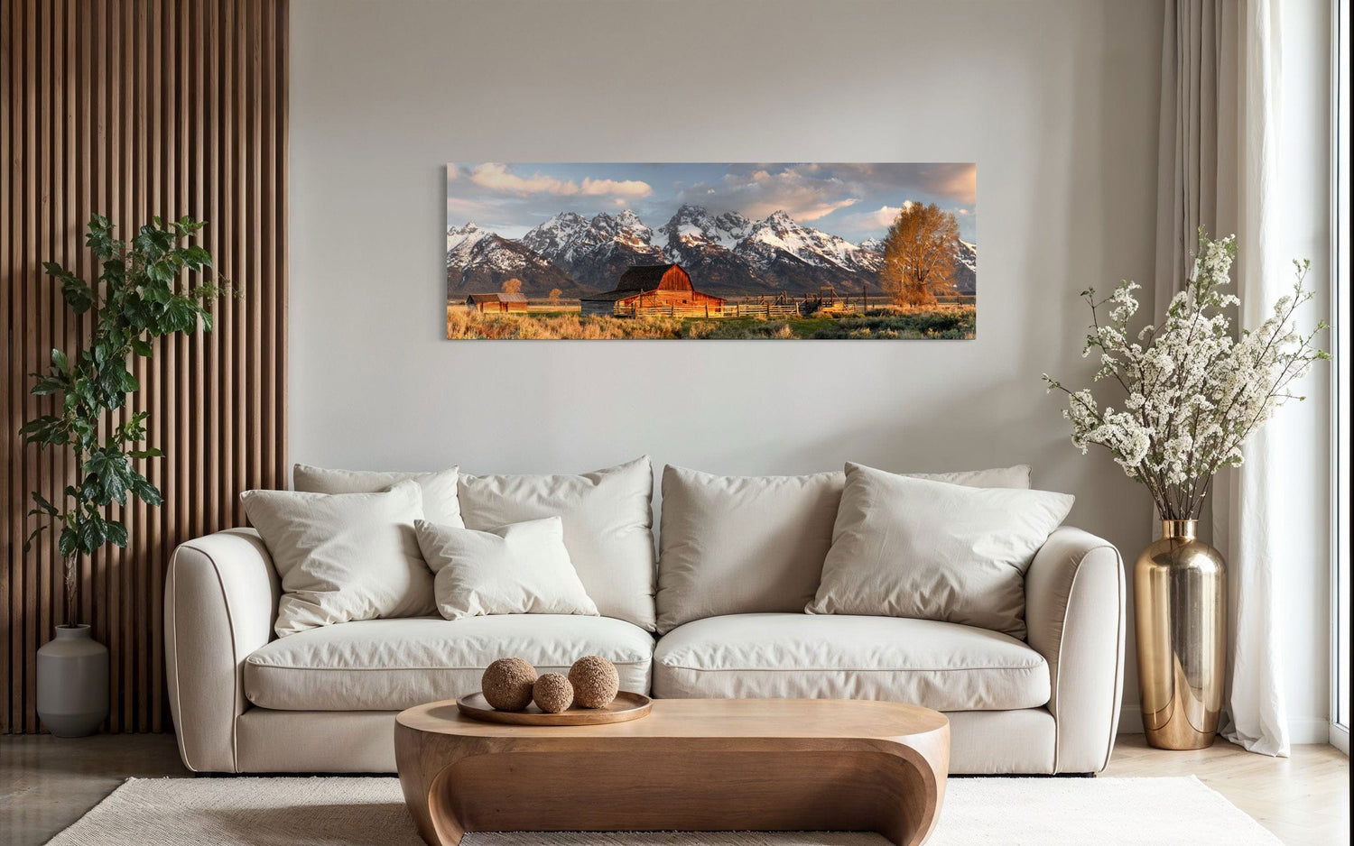 A piece of Jackson Hole art showing a photo of Mormon Row at the foot of the Grand Tetons hangs over a neutral couch.