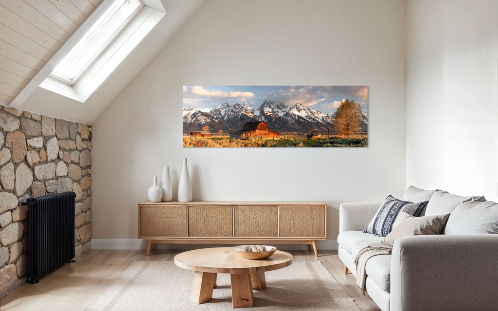 A piece of Jackson Hole art showing a photo of Mormon Row at the foot of the Grand Tetons hangs in a living space.
