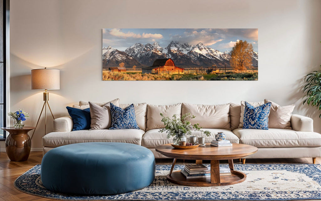 A piece of Jackson Hole art showing a photo of Mormon Row at the foot of the Grand Tetons hangs over a couch.