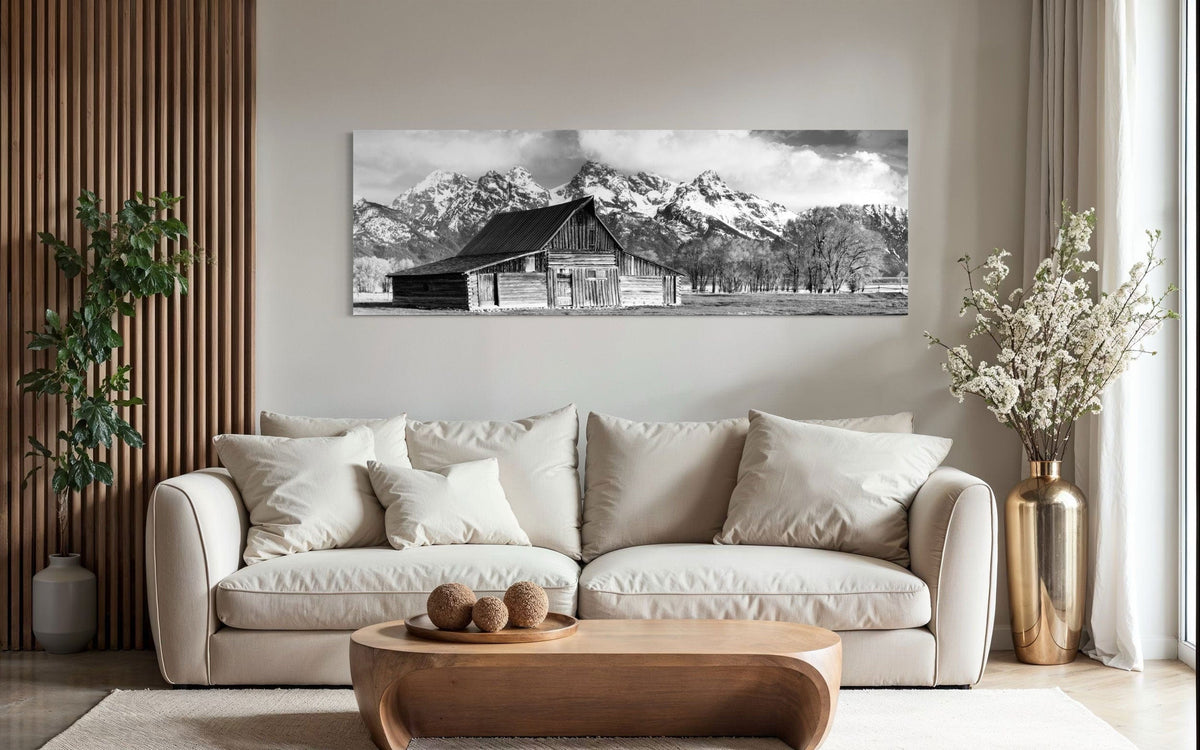 A piece of black and white wall art from Grand Teton National Park hangs above a couch.