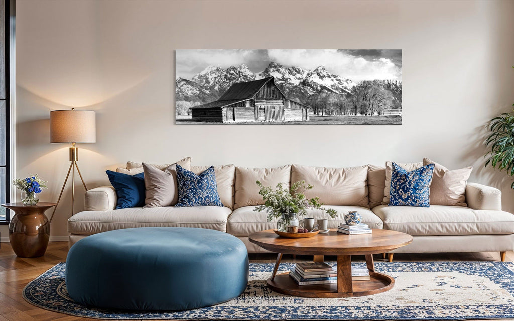 A piece of black and white wall art from Grand Teton National Park hangs in a living room above the couch.