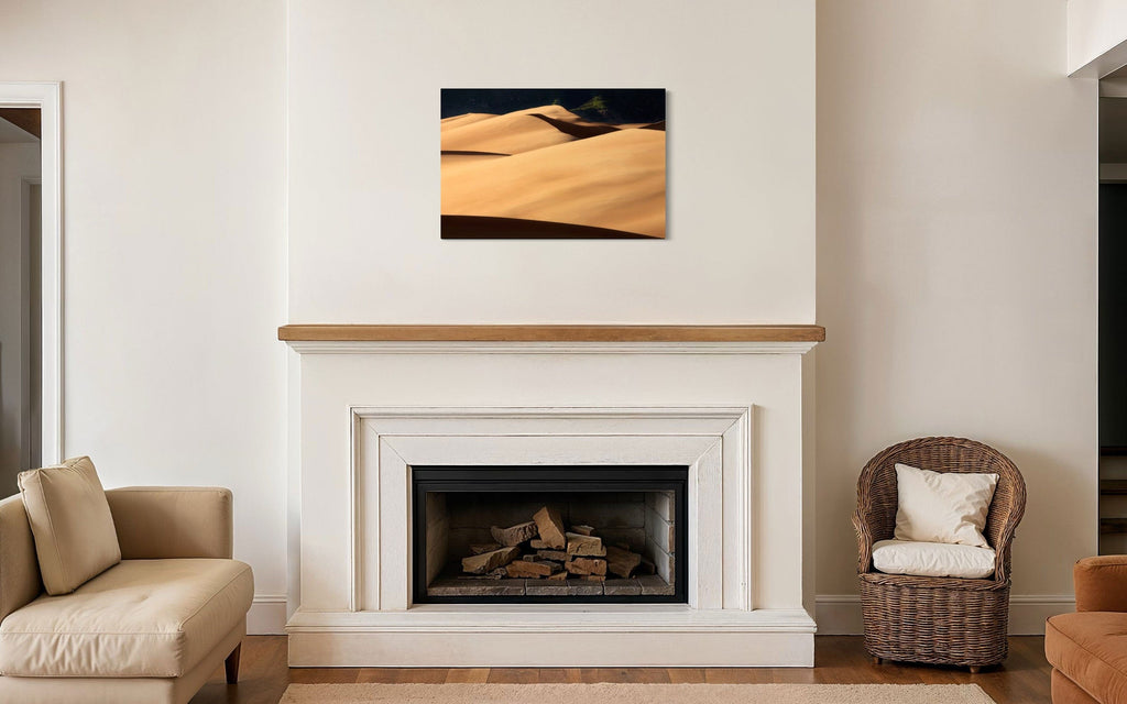 A piece of Colorado art showing a photo of Great Sand Dunes National Park hangs above a fireplace mantel.