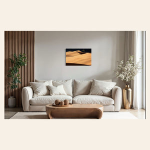A piece of Colorado art showing a photo of Great Sand Dunes National Park hangs above a couch.
