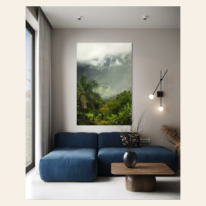 A piece of Kauai art showing the mountains seen from Hanalei hangs in a living room.