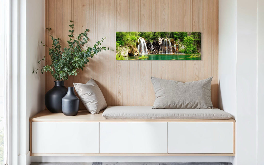 A piece of Colorado art showing a photo of the Hanging Lake waterfall hangs in a sitting area.